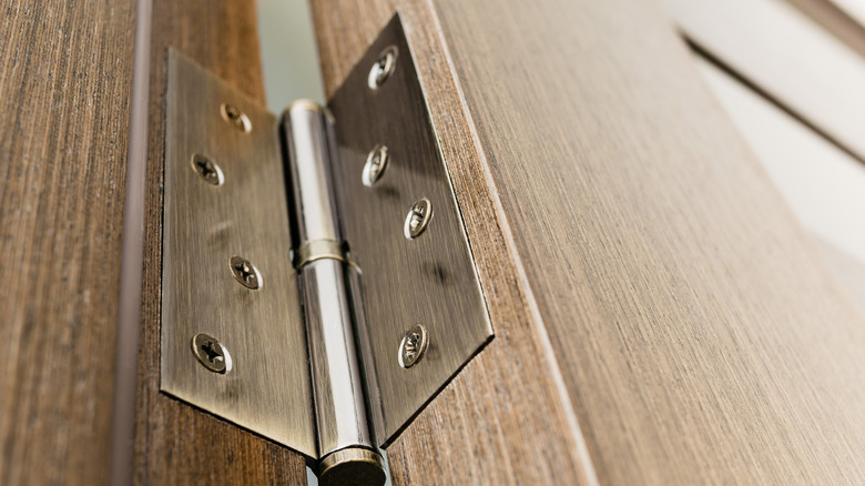 Close up of a door hinge on a wooden door frame