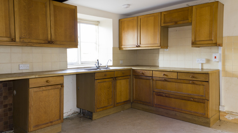 dingy looking wooden cabinetry with appliances gone