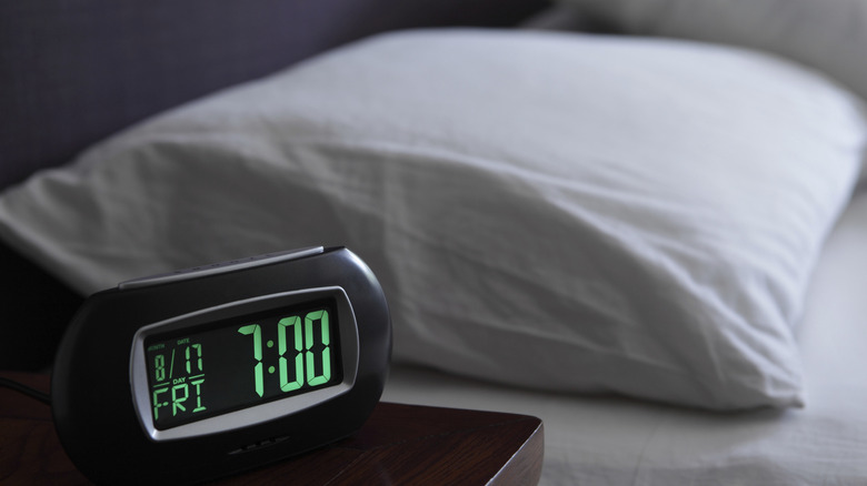 Close up of a digital clock on a nightstand showing 