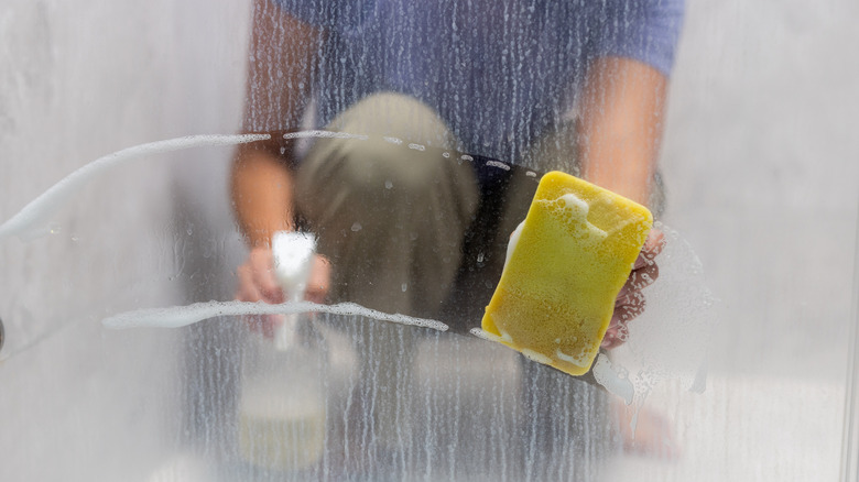 Person cleaning shower door