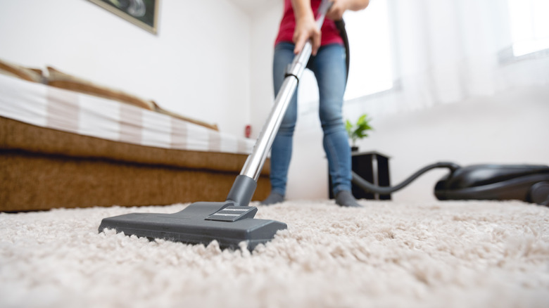 a woman vacuuming carpet