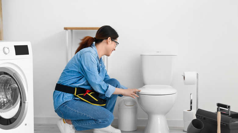 Woman fixing her toilet