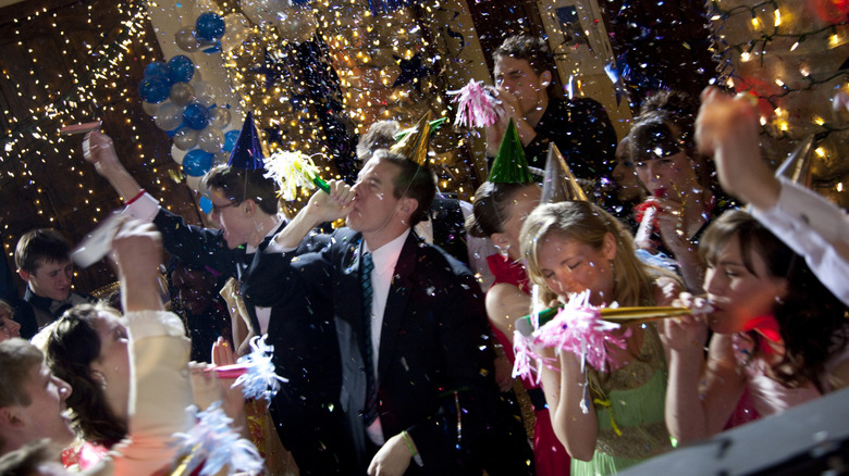 New Year's party with people blowing horns and confetti