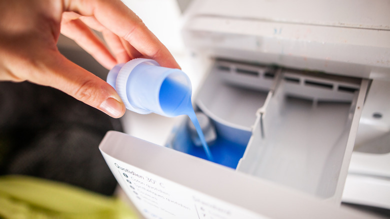 pouring fabric softener into washer