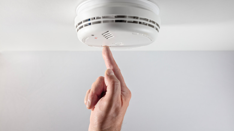 Pressing button on smoke detector