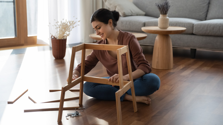 woman putting together MDF furniture inside of her home