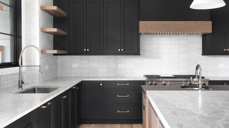 Kitchen with white granite countertops and black cabinets