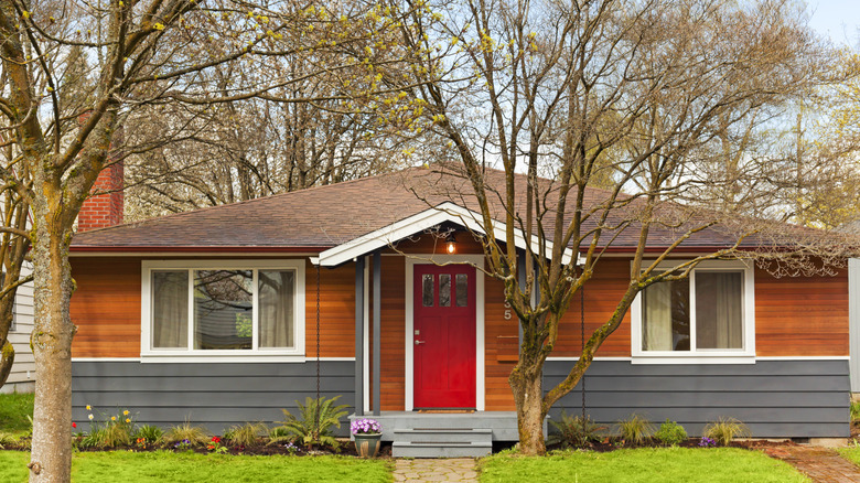 home with red door, wood, and grey panelling