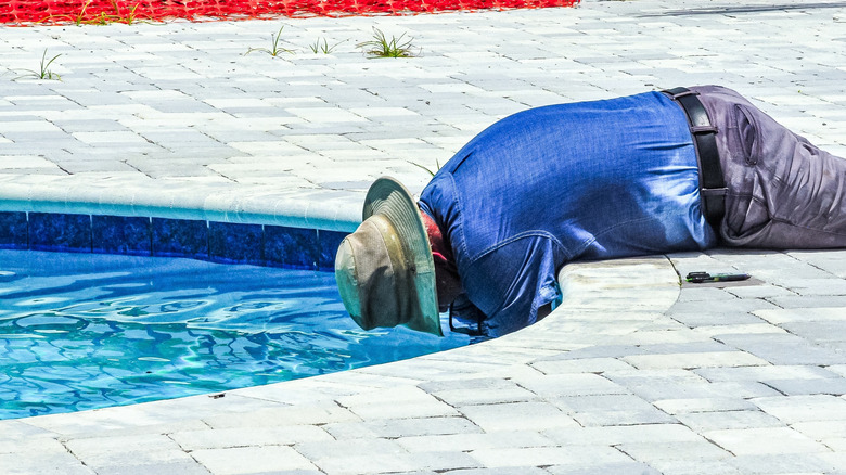 Man replacing swimming pool light