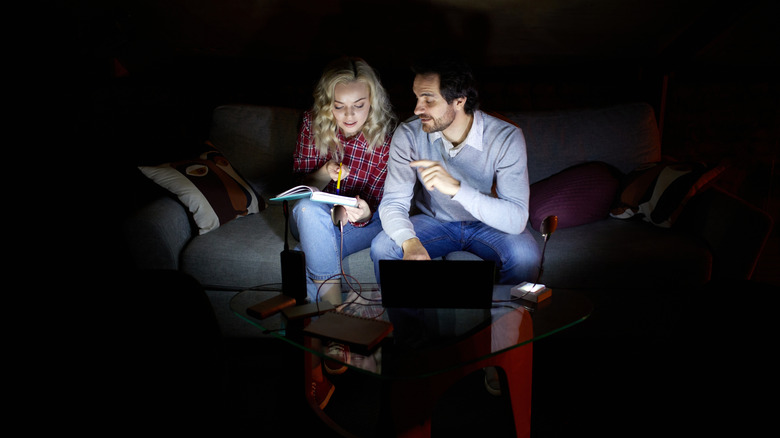 Couple discussing by light of a laptop during power outage