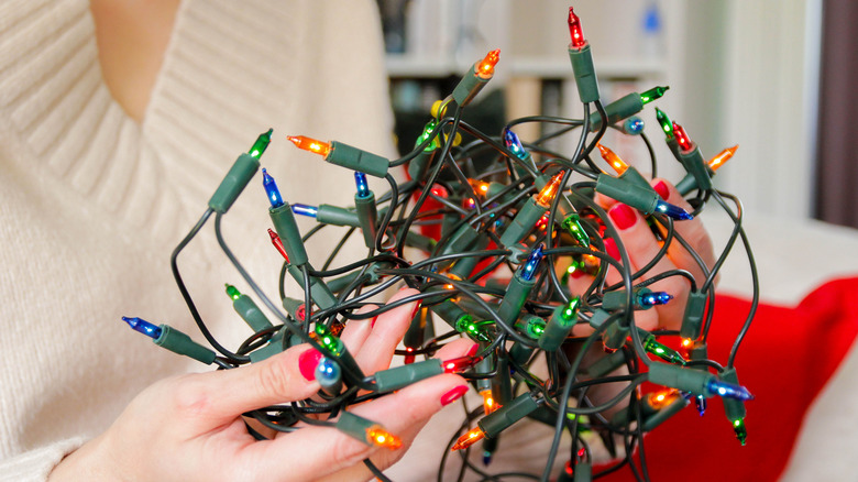 woman holding tangled colored christmas lights