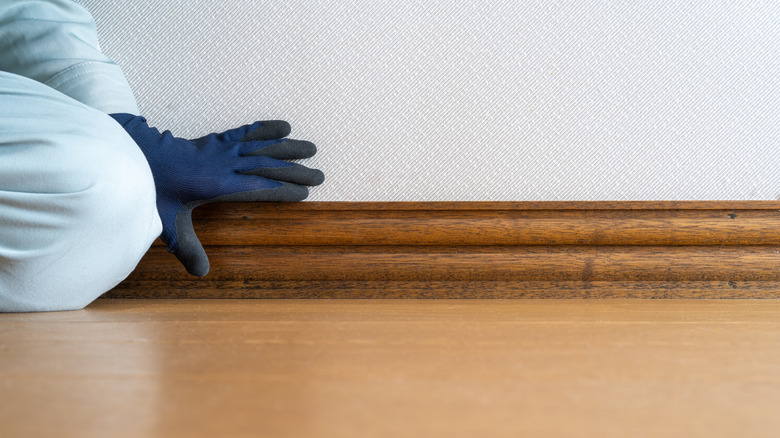 Worker checking baseboard