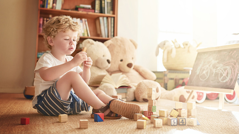 A child playing in the exploration zone of a bedroom