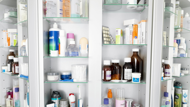 Bathroom cabinet full of pill and toiletry clutter