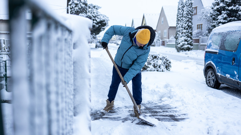 Person shoveling snow from driveway