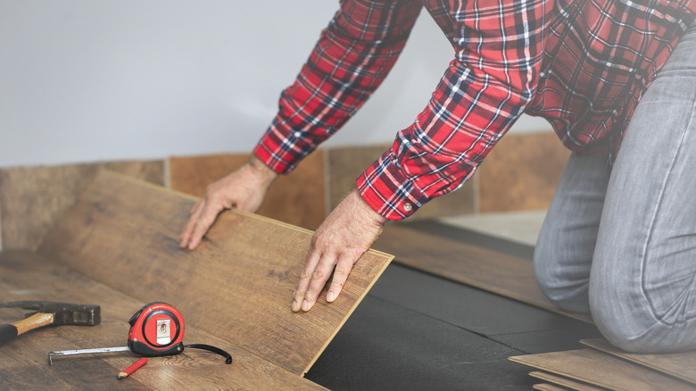 Man installing vinyl flooring planks