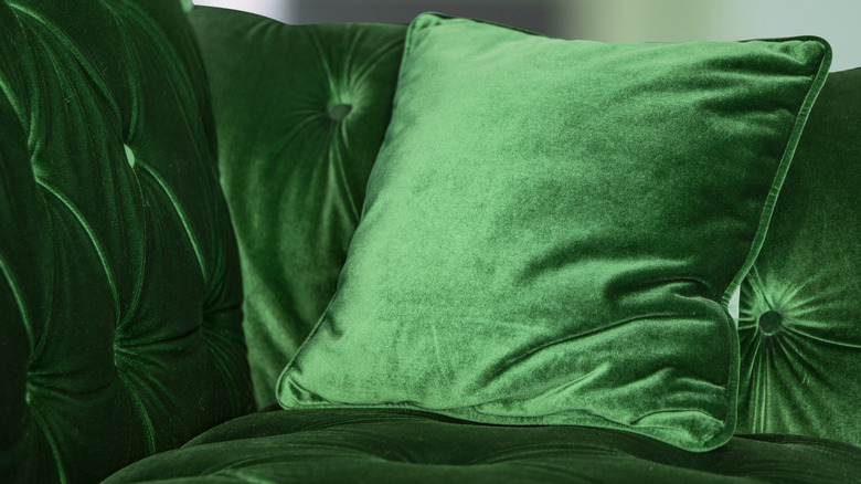 Living room with large green velvet couch as focal point