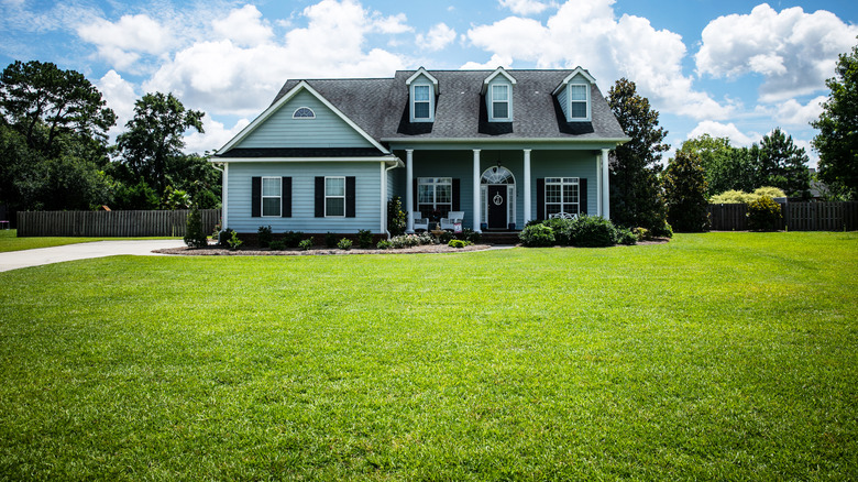 home with very large grassy front lawn