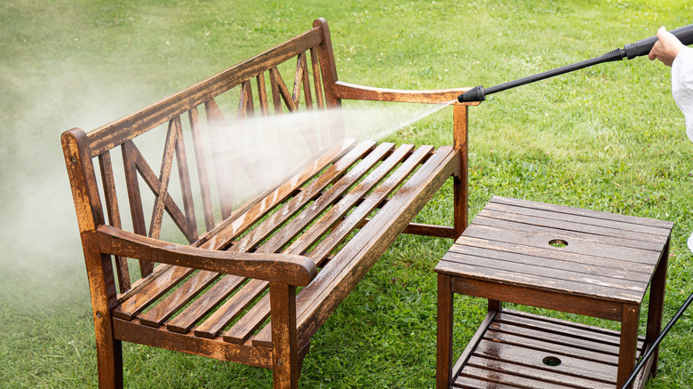 power washing outdoor bench on lawn