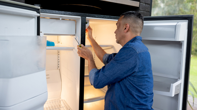 man looking into refrigerator