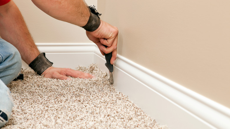 close up of hands installing carpet