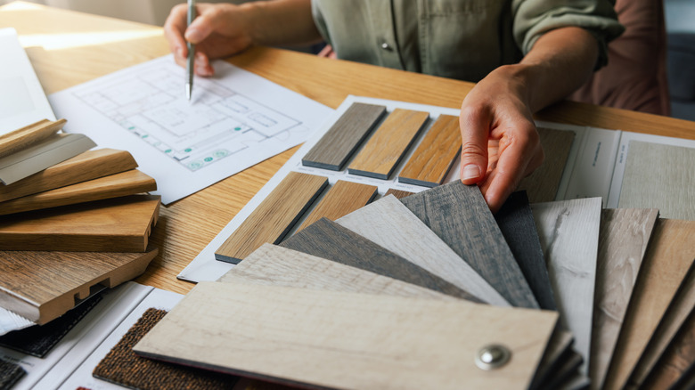 close up of designer looking at a variety of flooring samples