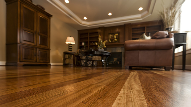 close up of dark hardwood floors in living room with furniture in the background