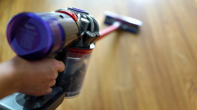 Hand holding Dyson cordless vacuum