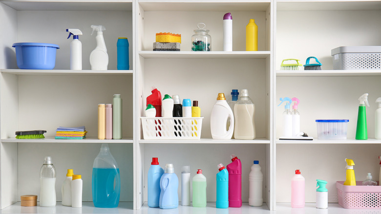 multiple rows of cleaning supplies on a plain white shelf