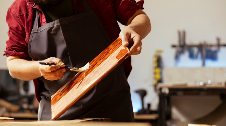 man brushing on wood finish