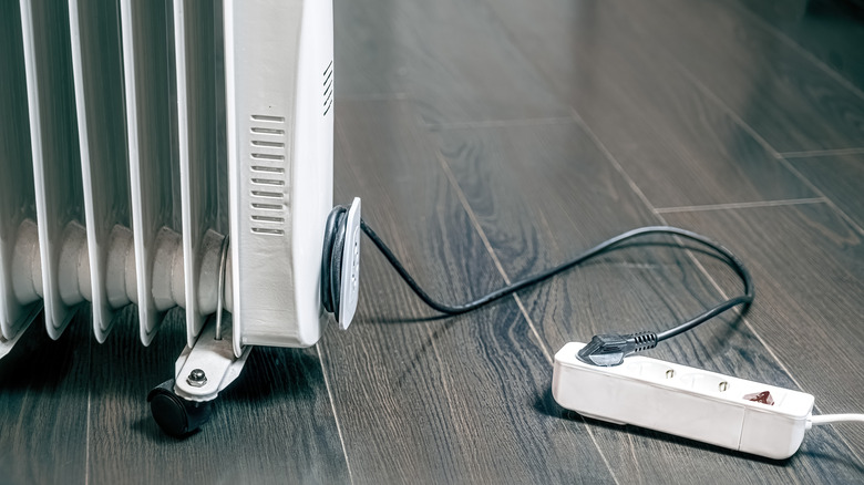 Oil-filled space heater plugged into a European-style power strip