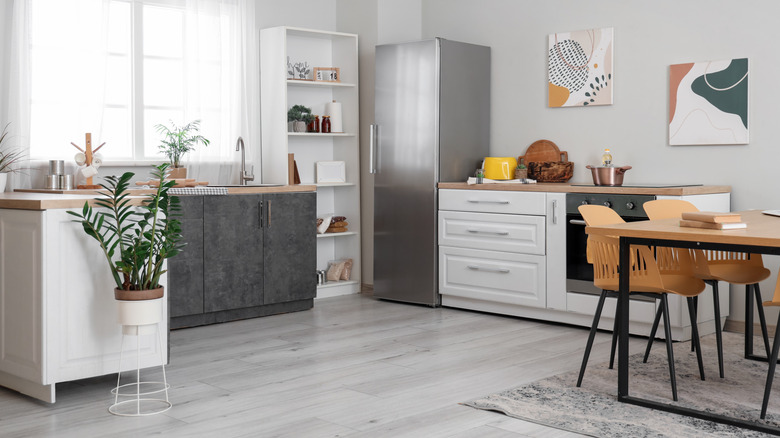 A sleek, modern kitchen with a stainless steel fridge prominent in the frame.