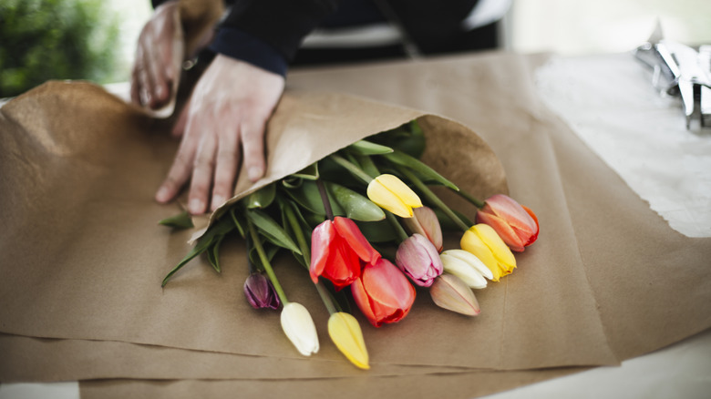 multiple colors of tulips in a bouquet wrapped in brown paper