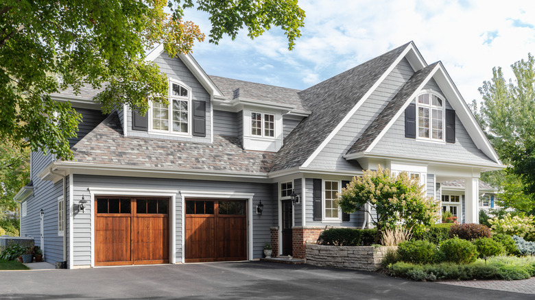 Gray home exterior with garage and overhanging tree