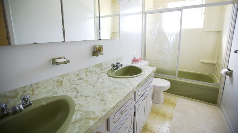 retro bathroom from the 1970s with avocado green sinks and bathtub