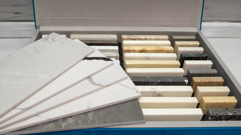 four large loose countertop sampled fanned out on top of a box of smaller, well-organized countertop samples