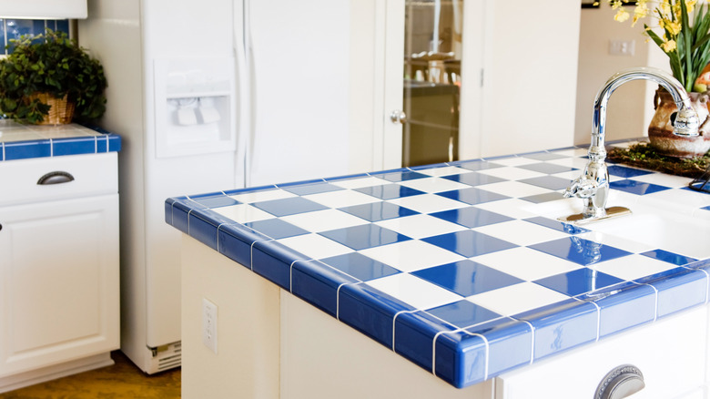 kitchen with blue and white diagonal checkerboard tile countertops with a blue tile edging