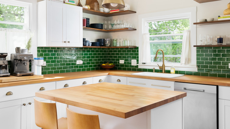 kitchen with butcher block counters and green backsplash