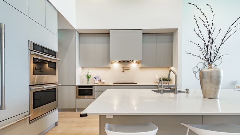 Modern kitchen with range hood behind cabinets