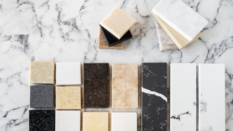 white marble countertop with black veining with an assortment of countertop samples lined up and in stacks on top