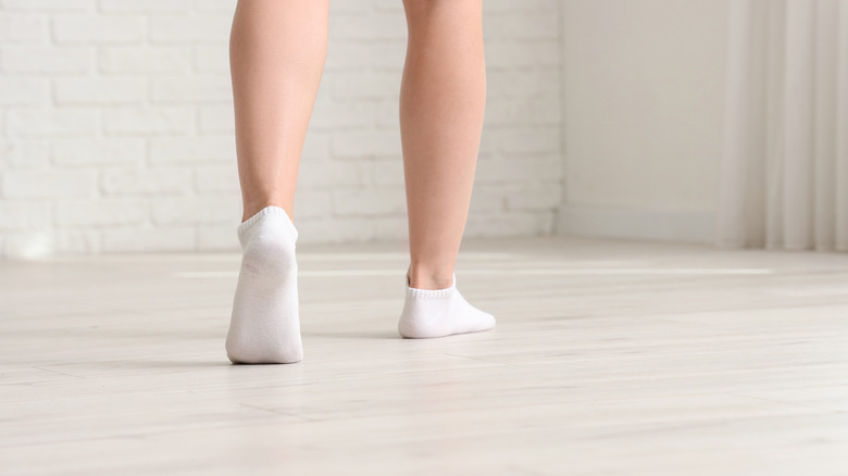 Woman walking on laminate floor in her socks.