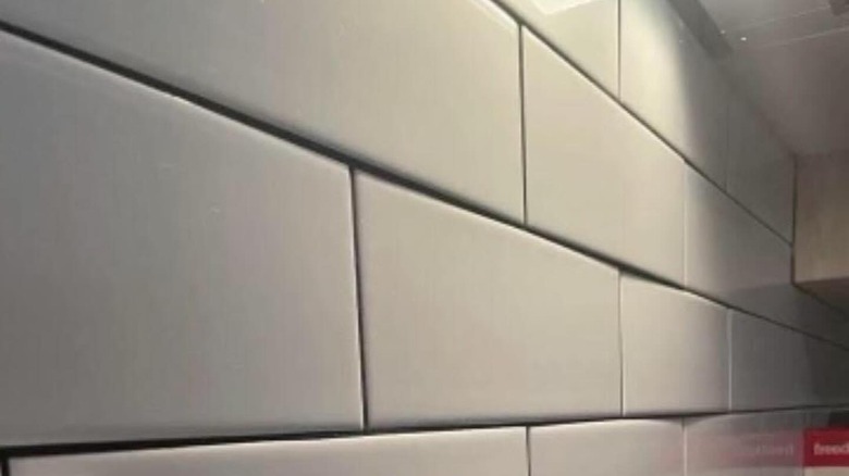 uneven white subway tile on wall