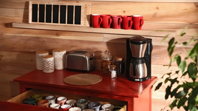 Coffee station with mugs in drawer and on wall shelf