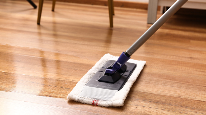 A mop gliding over a laminate floor.