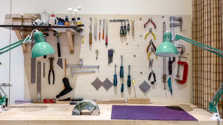 A workshop bench features a full wall of organized shelves and tools.