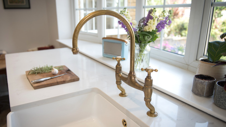 antique brass bridge faucet in kitchen