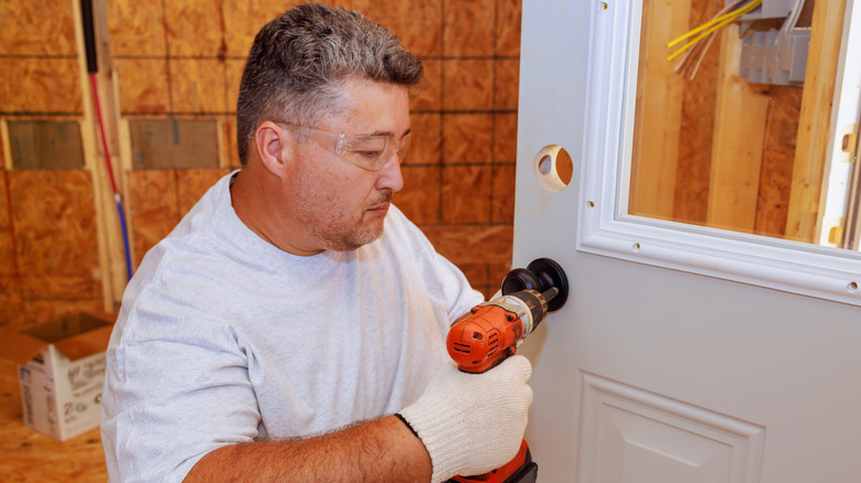 someone installing doorknob door