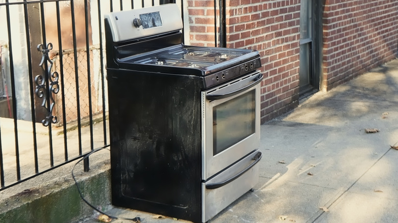 Discarded gas range on sidewalk