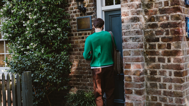 Man attempting to unlock his entryway