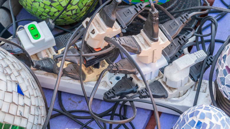 A dangerously overloaded electric circuit with many extension cords attached